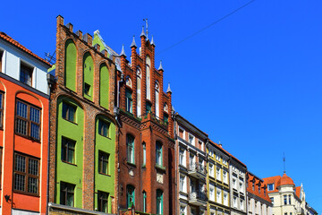 City view of the old buildings with colorful walls and decorative elements on the facades. Central square, old market with historical buildings. Old town. Torun, Poland, August 2023