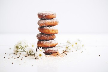stack of chocolate glazed donuts, white sugar dusting