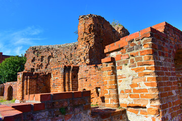 Old brick dilapidated wall. Ruins of the fortress. Ancient building against a blue sky background. Poland, Torun, August 2023.  