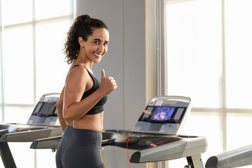 woman sportwear exercise running treadmill fitness in gym health club. sportswoman slim motivation...