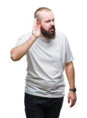 Young caucasian hipster man wearing casual t-shirt over isolated background smiling with hand over ear listening an hearing to rumor or gossip. Deafness concept.