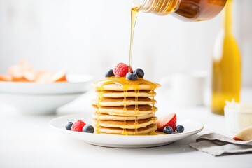 stack of vegan pancakes with maple syrup pouring - obrazy, fototapety, plakaty