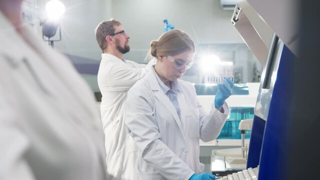 A medical research laboratory with a diverse team of biochemical scientists working with computers and modern medical technologies. Development of high-tech equipment for medicines.