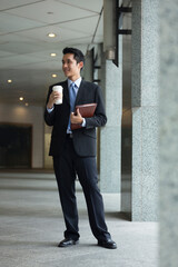 happy young Chinese business man in modern city