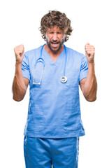 Handsome hispanic surgeon doctor man over isolated background excited for success with arms raised celebrating victory smiling. Winner concept.