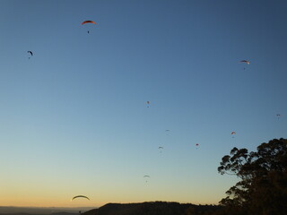 Hang-gliders in the sky, flying at sunset, Mount Tambourine, Queensland.