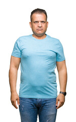 Middle age arab man wearing blue t-shirt over isolated background Relaxed with serious expression on face. Simple and natural looking at the camera.