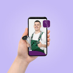Find plumber. Woman using mobile phone on light violet background, closeup. Specialist looking out of gadget