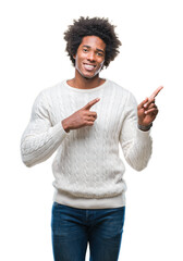 Afro american man over isolated background smiling and looking at the camera pointing with two hands and fingers to the side.