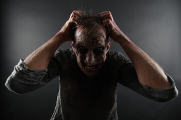 Scary zombie on dark background. Halloween monster