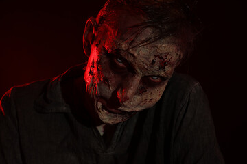 Scary zombie on dark background. Halloween monster