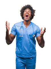 Afro american surgeon doctor man over isolated background crazy and mad shouting and yelling with aggressive expression and arms raised. Frustration concept.