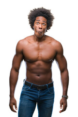 Fototapeta premium Afro american shirtless man showing nude body over isolated background making fish face with lips, crazy and comical gesture. Funny expression.