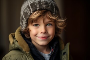 Portrait of a cute little boy with blond hair and blue eyes wearing warm clothes