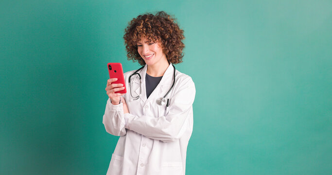Happy young woman doctor checking smartphone - Powered by Adobe