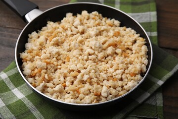 Fried ground meat in frying pan on wooden table, closeup
