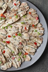 Tasty pickled anchovies with spices on grey textured table, top view