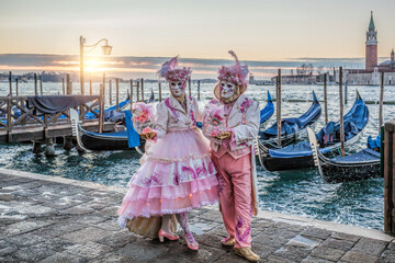 Colorful carnival masks at a traditional festival in Venice against gondolas, Italy - 711350139