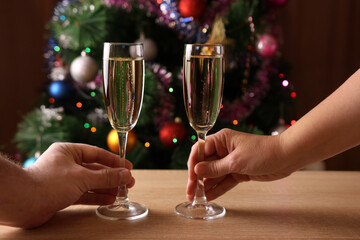 In the background, Christmas trees with twinkling garlands offer toasts with glasses of champagne