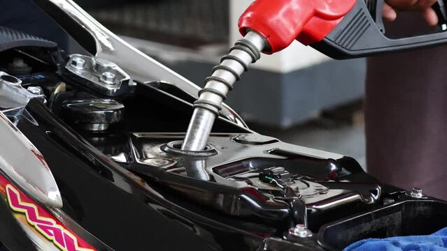 Refueling a Motorcycle at a Gas Station