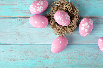 easter eggs and bird nest on rustic wooden background