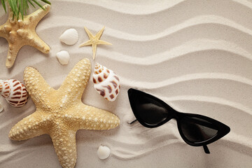 Fototapeta na wymiar seashells and sunglasses on sand beach
