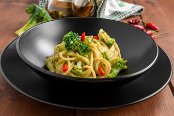 Piatto di saporiti spaghetti con peperoncino e salsa di broccoli, pasta italiana, cibo vegetariano 