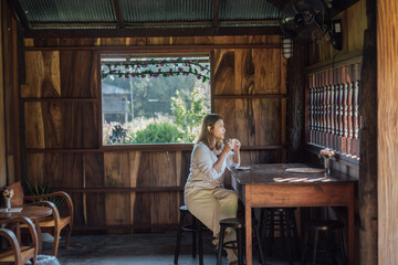 Obraz na płótnie Canvas woman drinks coffee and sitting in a cafe