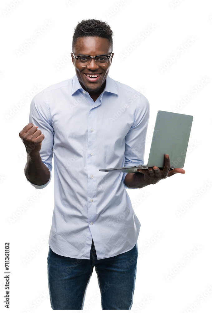 Wall mural Young african american businessman using computer laptop screaming proud and celebrating victory and success very excited, cheering emotion