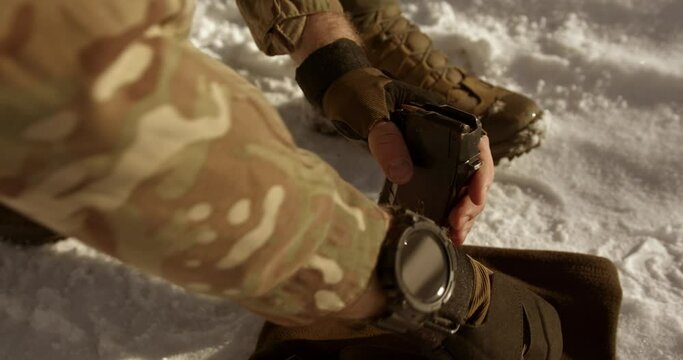 a soldier loads a rifle magazine with bullets. close-up a soldier loads his weapon