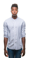 Fototapeta premium Young african american man over isolated background puffing cheeks with funny face. Mouth inflated with air, crazy expression.