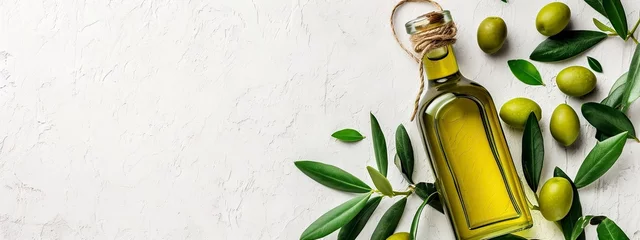 Fotobehang Extra Virgin Olive Oil in a Glass Bottle with Fresh Olives and Green Leaves on a Textured Background. © Juan