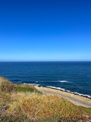 Ocean coast, clear blue sky, blue horizon, natural colors, no people