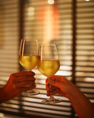 Young couple with two glasses of white wine in bed on the blurred background