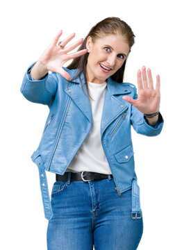 Beautiful middle age mature woman wearing fashion leather jacket over isolated background Smiling doing frame using hands palms and fingers, camera perspective
