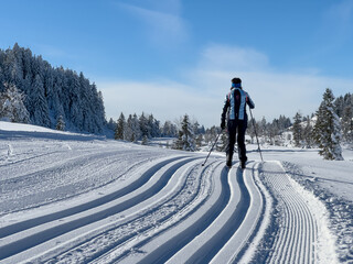 Fototapeta na wymiar beautiful active senior woman cross-country skiing in fresh fallen powder snow in the Allgau alps near Immenstadt, Bavaria