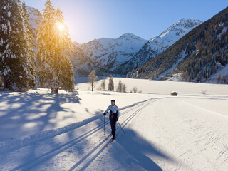 beautiful active senior woman cross-country skiing in fresh fallen powder snow in the in the Tannheim Valley, Tyrol, Austria