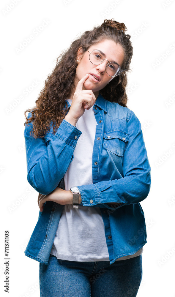 Sticker beautiful young brunette curly hair girl wearing glasses over isolated background with hand on chin 