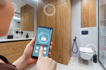 Close up smartphone in female hand with smart home system app interface on cellphone screen, young woman controlling all house system by phone in modern apartment, internet of things concept.