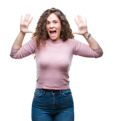 Beautiful brunette curly hair young girl wearing pink sweater over isolated background showing and pointing up with fingers number ten while smiling confident and happy.