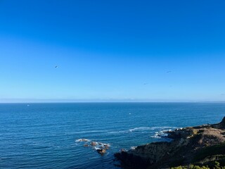 Ocean coast, clear blue sky, blue horizon, natural colors, no people