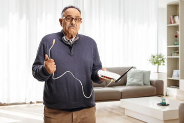 Confused mature man holding a router cable