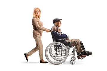 Middle aged woman pushing a senior with a broken arm in a wheelchair