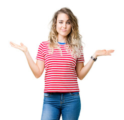 Beautiful young blonde woman over isolated background clueless and confused expression with arms...