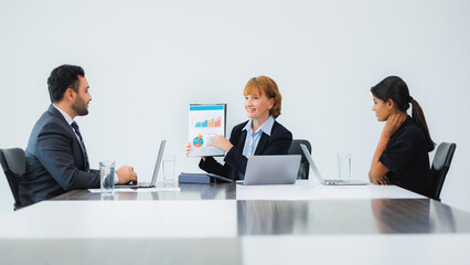 Three smiling diverse business colleagues having sit down business strategy meeting.