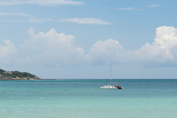 Obraz premium A small sailing boat in a beautiful sea bay, relaxing during the beatiful summer