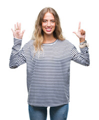 Fototapeta na wymiar Beautiful young blonde woman wearing stripes sweater over isolated background showing and pointing up with fingers number seven while smiling confident and happy.