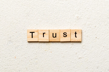 TRUST word written on wood block. TRUST text on table, concept