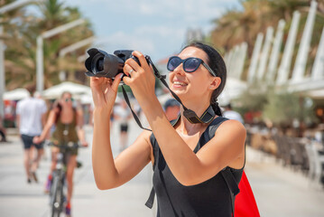 Tourist with a camera photographing the streets and points of interest on a sunny day.