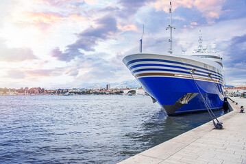 Pleasure ship on the sea waves. The yacht is moored to the shore in the port.
